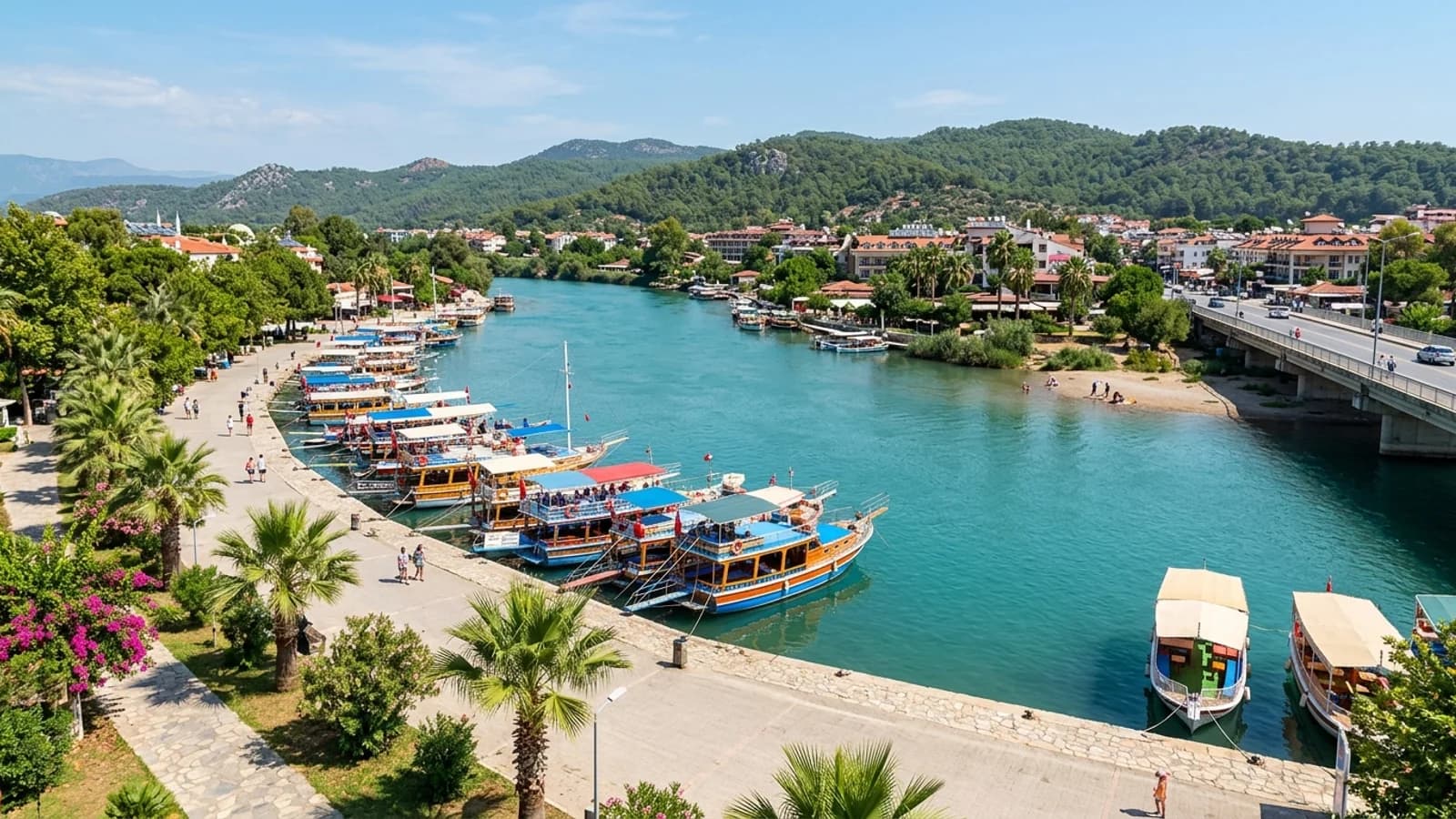 Des bateaux d'excursion en bois sont amarrés le long des quais ombragés de la large rivière Manavgat.